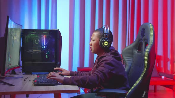 Male Gamer Wearing Headphones Feeling Disappointed During Shooting Video Game alt