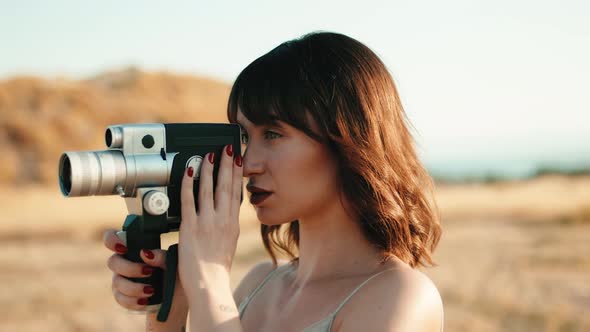 Pretty Girl with Vintage 8Mm Camera in the Countryside alt