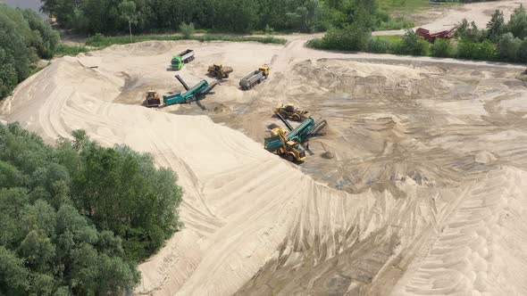 Aerial view of mining machinery working at sand quarry. Mining equipment alt