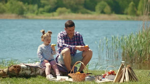 Father with Little Daughter on a Picnic Near the River alt