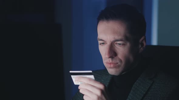 Young Man Using Computer Laptop and Shopping Online with Credit Card While Sitting at Workplace Late alt