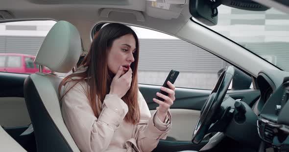 Scared Young Woman Looking in Smartphone with Big Eyes Shocked Expression Closing Mouth Zipping Lips alt