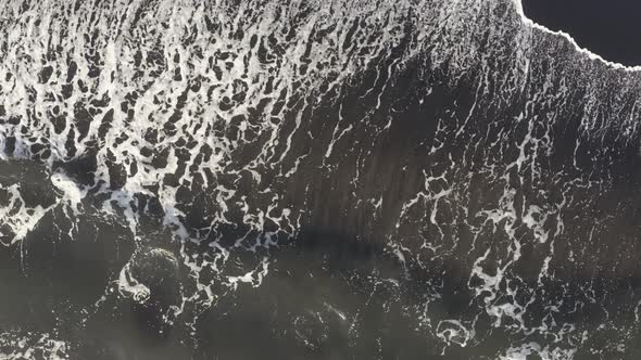 Aerial View Powerful Ocean Waves at Black Volcanic Beach Crashing and Foaming. alt