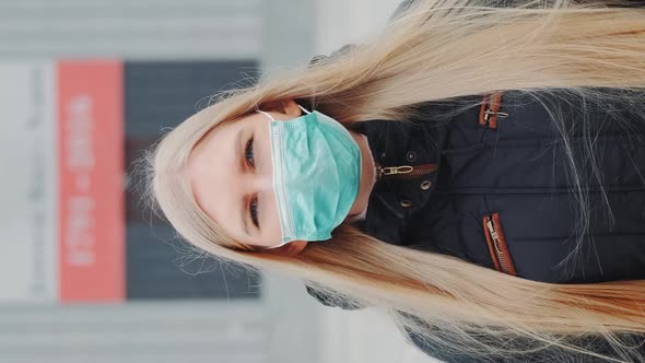 Medium Shot of Blonde Woman in a Medical Mask Walking Down the Street alt