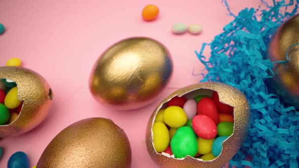 Golden Eggs with Scattered Sweets for Easter on Pink Background