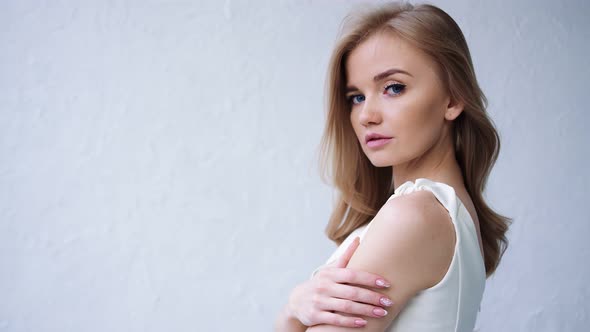 Portrait of Handsome Girl with Fashion Makeup and Waving Hair Posing alt