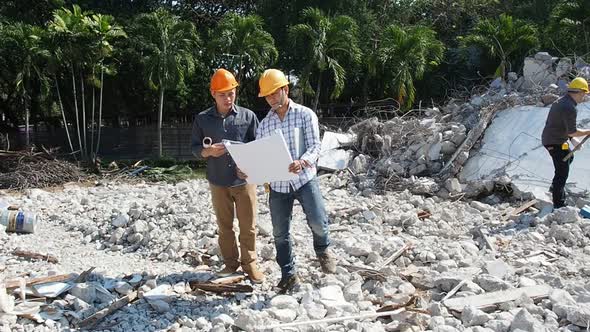 Demolition control supervisor and foreman discussing on demolish building.