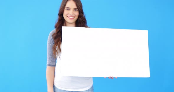 Beautiful woman holding blank placard on blue background alt