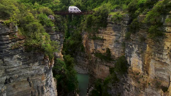 Aerial shot in between two rocky cliffs and canyons. With a river flowing in between them and lush g alt