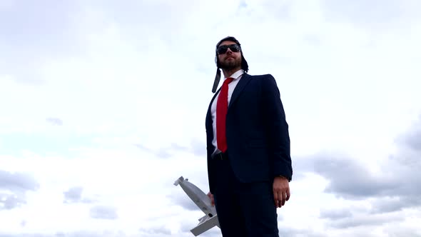 Man in Business Suit and Pilot Hat with Glasses Hold Plane Success