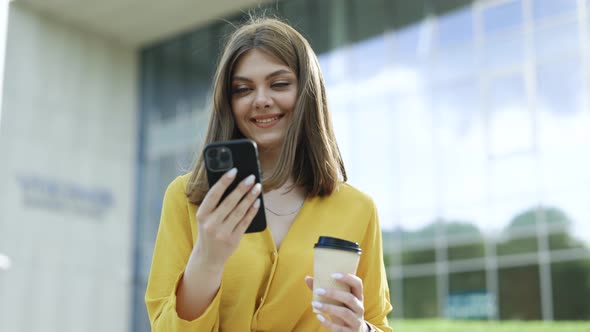 Joyful Young Attractive European Business Girl Using Mobile Phone Drinking Coffee Spending Time