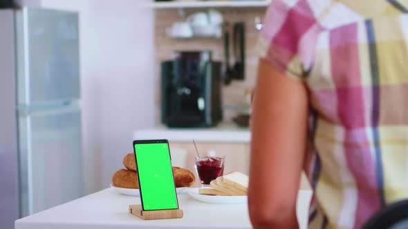 Woman Looking at Smartphone with Green Screen alt