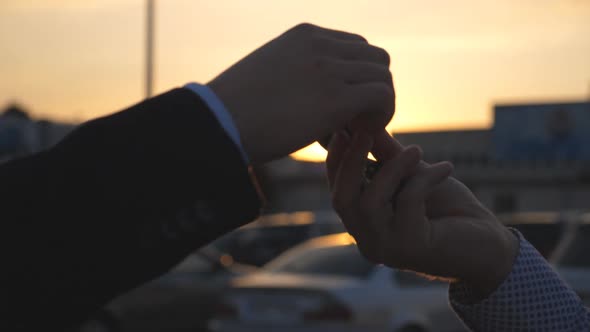 Male Hands Giving Keys of Car to His Friend with Sun Flare at Background alt