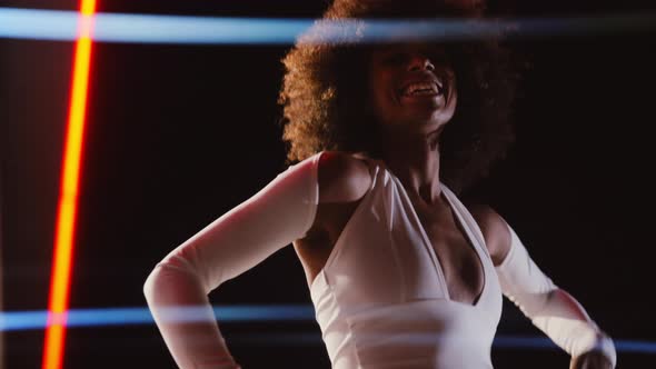 Woman With Afro In Jumpsuit Posing In Gas Station At Night alt