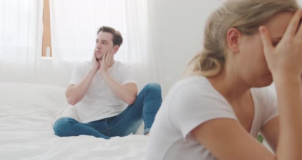 Caucasian attractive angry young couple having arguement topic fighting on bed in bedroom at home. alt