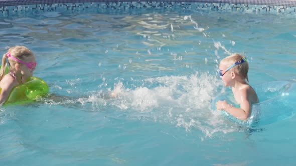 Little Boy and Girl Swimming in Swimming Pool Children Having Fun Splashing Water alt