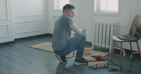 Man is Building Furniture Himself Making Renovation at Home alt