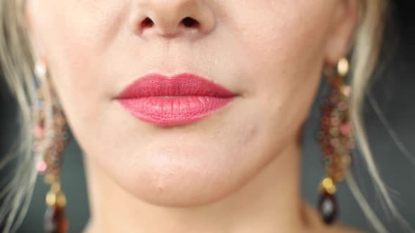 Extreme Close-up Female Mouth with Pink Lipstick Smiling Showing White Healthy Beautiful Teeth