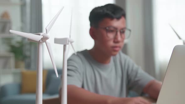Blur Kid Or Student With Laptop Computer Programming Electric Wind Turbine Model At Home alt