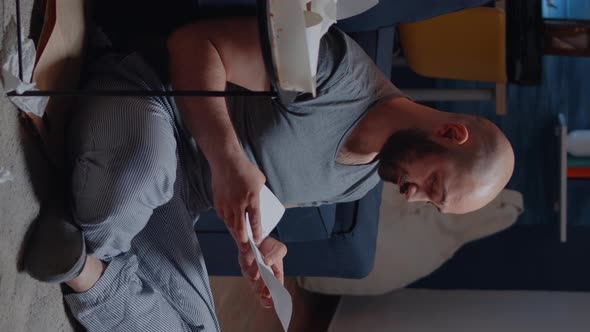Vertical Video Desperate Adult Man Sitting on Floor Reading with Tears Eviction Notice alt