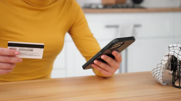 Close Up Woman Enters Credit Card Code to Pay Gifts Online Shopping Smartphone alt