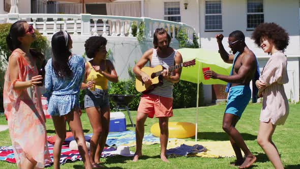 Diverse group of friends having fun and dancing at a pool party alt
