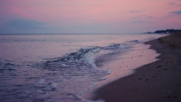 Purple Sky Reflecting at Sea Water Surface at Cold Evening Sunset alt