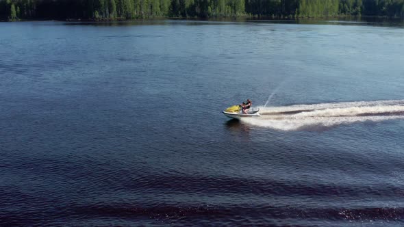 Mom and Daughter Ride Along the River on a Personal Watercraft alt