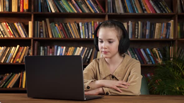 Lady Junior Student in Black Headphones Listens to Teacher alt