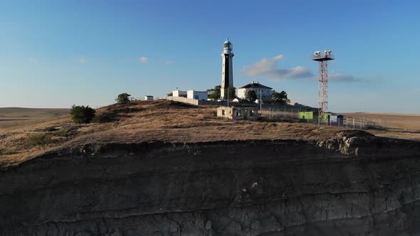 Aerial View of the Coastal Maritime Lighthouse Stands on the Seashore or Ocean alt