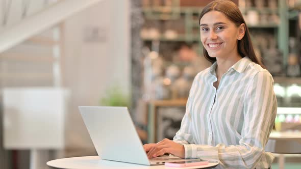 Serious Young Latin Woman with Laptop Saying No By Head Shake  alt