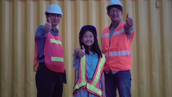 Happy family standing with showing thumbs up at container cargo site alt