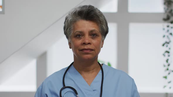 Portrait of senior african american female doctor looking at camera and smiling alt
