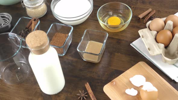 Eggnog ingredients in glassware containers on the table in the kitchen prepared for cooking