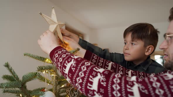 Father and son decorating the Christmas tree. Shot with RED helium camera in 8K alt