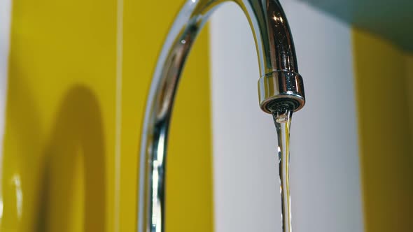 Water Running From the Tap Into a Sink. Slow Motion alt