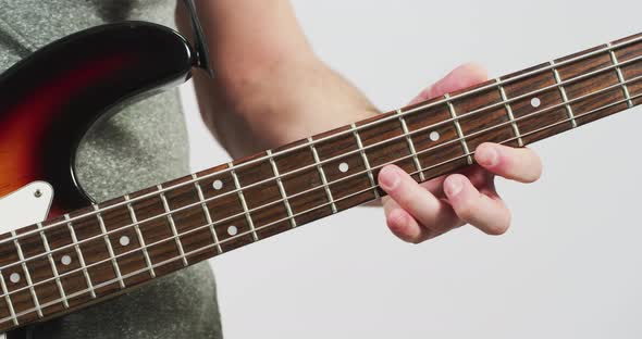 Fingers playing on the fretboad of an electric guitar alt