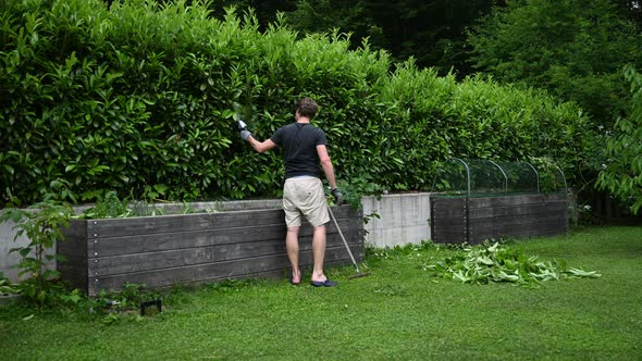 Timelapse Of A Young Man Cutting The Hedge
