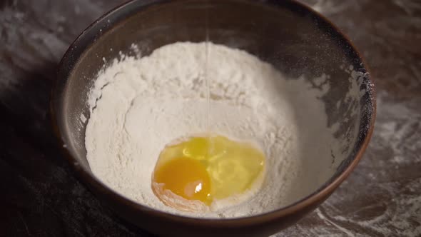 Slow Motion of Falling Eggs Into Flour in Bowl