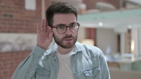 Portrait of Sneaky Young Male Designer Listening Carefully alt