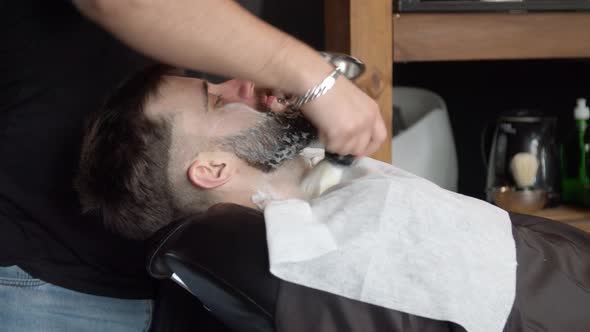 Barber Applying Shaving Foam on Beard of Client