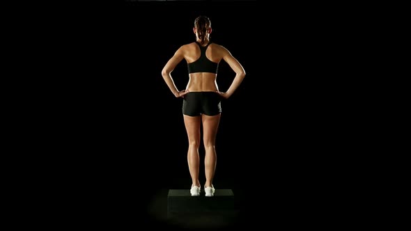Young Athletic Woman Wearing Sporstwear is Exercising with Step Slow Motion Isolated on Black Loop