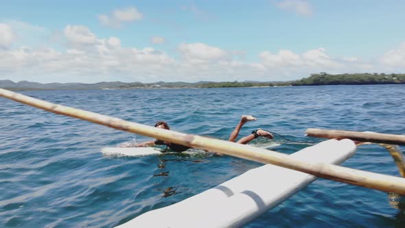 Man lying on surfboard and paddling, Philippines alt
