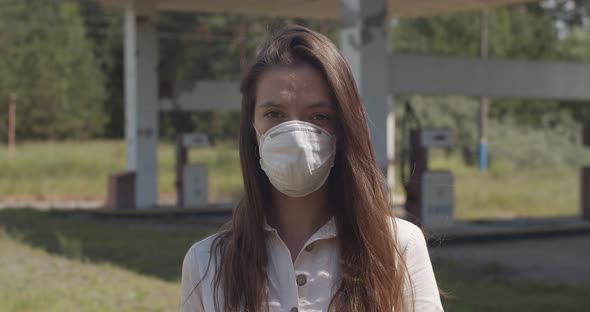 Close Up Portrait of Girl Wearing Pandemic Protective Mask Outdoors Handheld Device. Young Woman