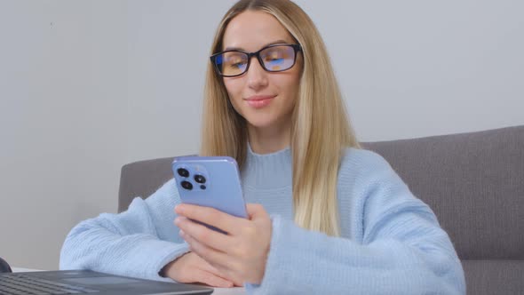 Happy white female using modern blue mobile phone for online communication in 4k video alt