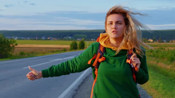 Beautiful Blonde Girl with Backpack Hitching Ride alt
