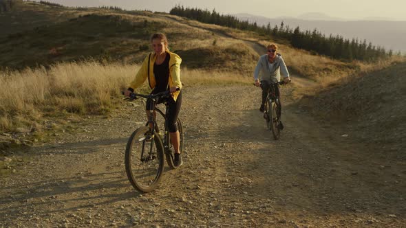 Couple Cycling on Sport Bikes in Mountains alt