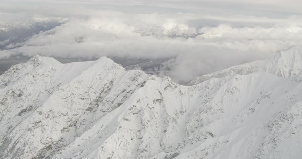 Aerial helicopter wide shot of bay, over forest, mountains in distance, drone footage