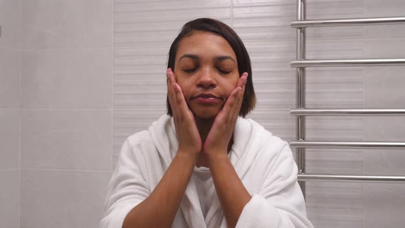 Beautiful Woman Washes Her Face with Water in the Bathroom