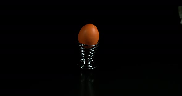 Egg and Egg Cup that bounce on black background, Slow Motion 4K alt